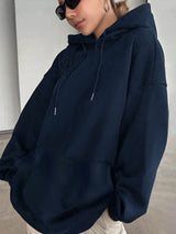 Person wearing a navy blue hoodie and sunglasses indoors